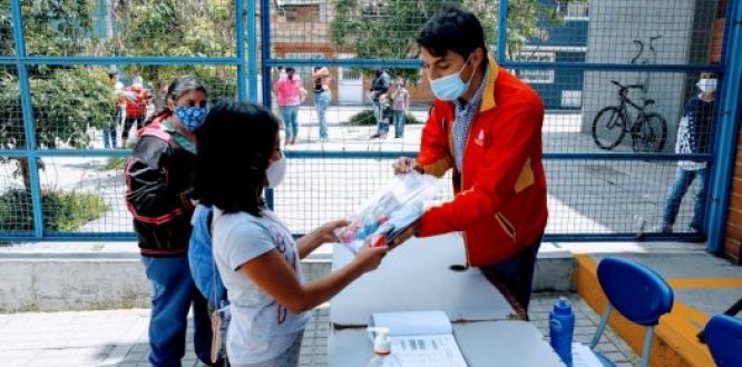 El alcalde de Suba, Julián Moreno, entrega a una niña un kit como reconocimiento por participar en las vacaciones recreativas.