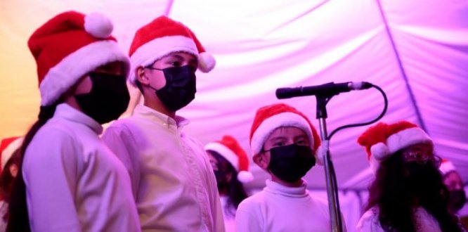 Niños del coro de Batuta de Suba, cantando villancicos, con gorros de navidad