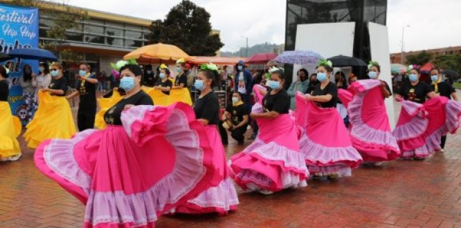 Bailarinas ganadoras de la beca Es Cultura Local, con faldas rosadas, danzando en la plazoleta del Portal de Suba de Transmilenio